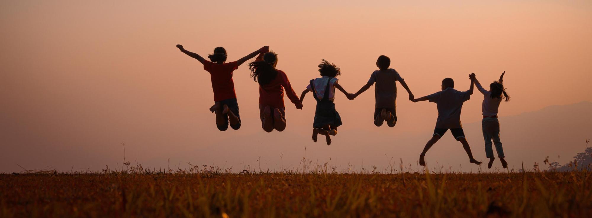 kids jumping in sunset