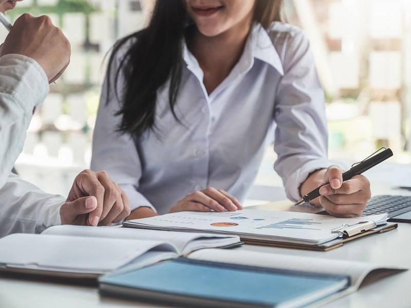 man and lady working on desk with clipboard