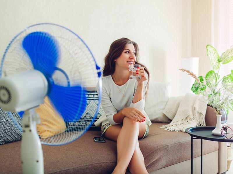 woman on couch with portable fan