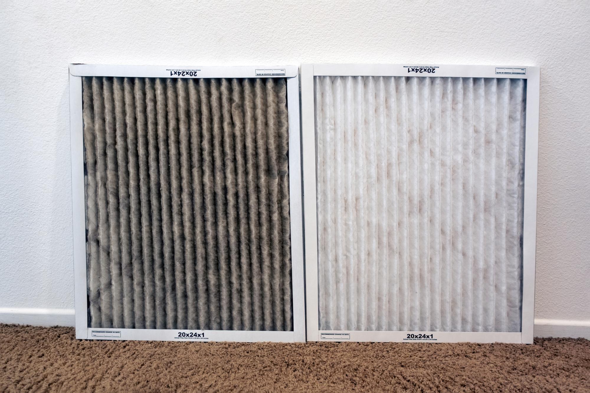 Dirty air filter sitting next to a clean air filter to show how bad a dirty filter looks