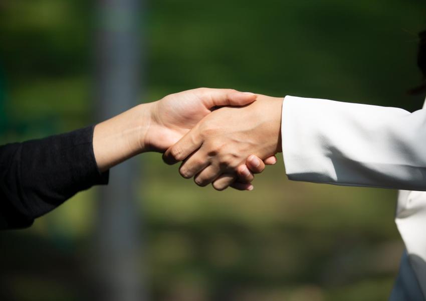 Two people shake hands.